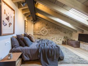 a bedroom with a bed and a stone wall at Villa Age in Puigcerdà