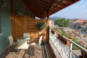 balcón con mesa de cristal y sillas blancas en Európa Penzión, en Štúrovo