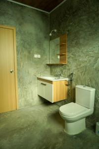 a bathroom with a white toilet and a sink at The Zen Den in Thulusdhoo
