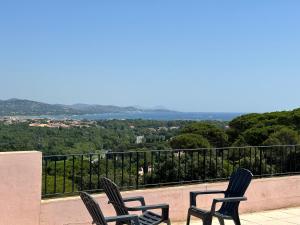 two chairs sitting on a balcony with a view at mazet proche de st Tropez in Cogolin