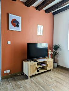 a living room with a flat screen tv on a wall at La Petite Chaume in Châteauroux