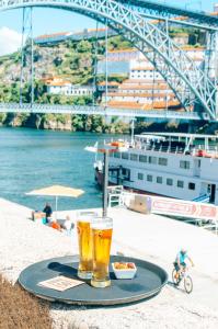 dois copos de cerveja num tabuleiro com um navio de cruzeiro em Stay In Apartments no Porto