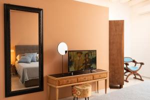 - une chambre avec un miroir et une télévision sur une commode dans l'établissement Ficupalas, à Syracuse