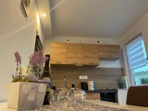 una cocina con fregadero y una mesa con copas de vino en Apartma Lavanda, en Koper