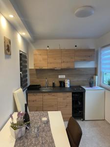 a kitchen with a table and a sink and a refrigerator at Apartma Lavanda in Koper