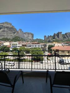 a view of a city from a window with chairs at KONTOYLIS APARTMENT in Kalabaka