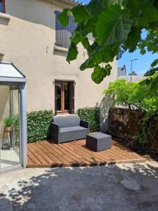 patio z 2 kanapami na drewnianym tarasie w obiekcie Gîtes Le Lilas - Lac de Pareloup w mieście Canet-de-Salars