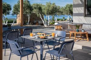a table and chairs with food on a patio at Anthos in Frangokastello