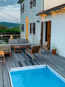 a deck with a pool and a couch and chairs at Grant's in Labin