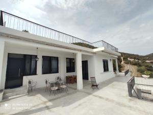 a white house with a patio with a table and chairs at Villa Konstantina in Panayía