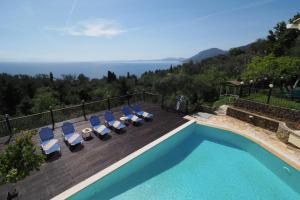 a villa with a swimming pool and lounge chairs at Ionian Blue in Perama