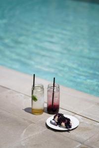 un plato de comida y dos bebidas junto a una piscina en Guest house Wishmore en Banya