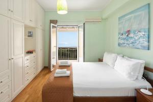 a bedroom with a large bed and a large window at Ionian Blue in Perama
