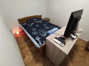 a bedroom with a bed and a television on a desk at Aretha apartman i sobe in Novi Vinodolski
