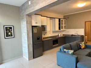 a living room with a couch and a kitchen at St Ives beach access apartment in Margate
