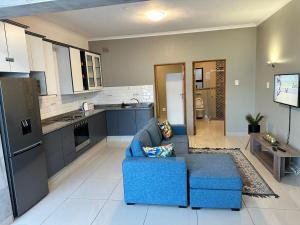 ein Wohnzimmer mit einer blauen Couch in einer Küche in der Unterkunft St Ives beach access apartment in Margate