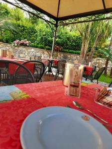 a white plate on a table with a red table cloth at Hotel Garibaldi in Milazzo