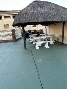 - un pavillon avec des tables de pique-nique et un toit de paille dans l'établissement St Ives beach access apartment, à Margate
