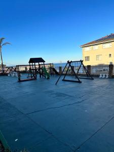 a playground in a parking lot next to the ocean at St Ives beach access apartment in Margate