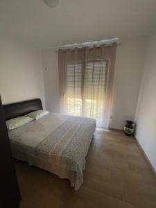 a bedroom with a bed and a large window at Orlovs Family in Dobra Voda