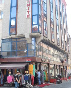 a store on the corner of a street with people standing outside at Red White Hotel in Istanbul