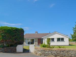 une maison blanche avec un mur en pierre dans l'établissement Valley Truckle Bungalow, à Camelford