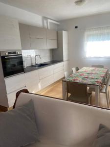 a kitchen with a table and chairs and a kitchen with white cabinets at Casa Camilla in Colico