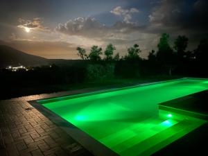 a swimming pool with green illumination at night at La Casa Nell'Oliveto Bed & Breakfast in Acquasparta