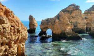 an arch in the ocean between two rocky cliffs at Modern 2BR Apartment Private Parking Walk to Dona Ana Beach & Lagos Old Town in Lagos