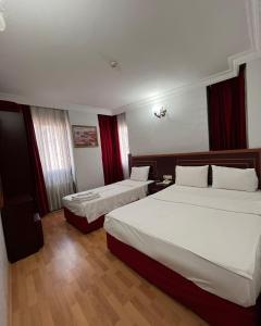 a hotel room with two beds and red curtains at Red White Hotel in Istanbul