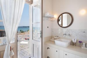 ein weißes Badezimmer mit einem Waschbecken und einem Spiegel in der Unterkunft Nars Ilica Hotel Beach Adults Only 12Plus in Cesme