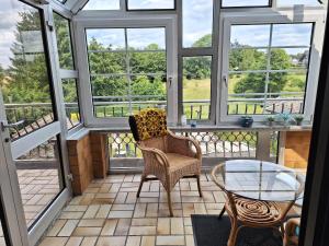 a screened in porch with two chairs and a glass table at Eifelliebe Monschau in Monschau