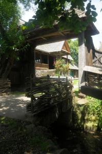 un puente de madera frente a un edificio en The Village Pension en Breb