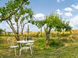 a table and chairs sitting under a tree in a field at Ceiliog Bach in Llangennith
