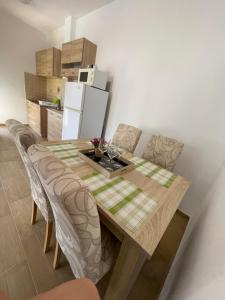 a kitchen with a table with chairs and a refrigerator at Orlovs Family in Dobra Voda