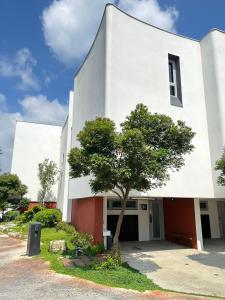 a white building with a tree in front of it at 上水民宿 in Chiayi City