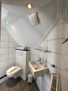 ベルグ・エン・テルブレイトにあるホテル ドゥ ランゲ アッカーの白いバスルーム(洗面台、トイレ付)