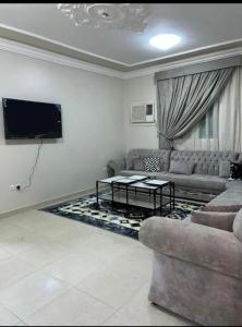 a living room with a couch and a tv at شقق بدور أرضي in Al-Salam
