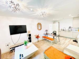 a living room with a couch and a tv at Chattel Bedford in Bedford