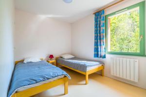 1 dormitorio con 2 camas y ventana en Gîtes De La Barbotine, en Le Fuilet