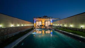 a swimming pool in front of a building at night at VİLLA ADA in Kaş