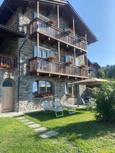 ein Steinhaus mit einem Balkon und einer Bank in der Unterkunft Casa Camilla in Colico