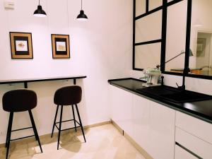 a bathroom with a black counter and two stools at I Canti Comfort Rooms in Palermo