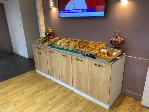 a buffet line with pastries and a television on a wall at Kyriad Montargis Amilly in Amilly +16 photos