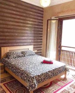 een slaapkamer met een bed met een houten muur bij Appartement avec vue sur l'Atlas et piscine in Marrakesh