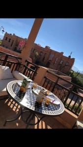 a table on a balcony with two drinks on it at Appartement avec vue sur l'Atlas et piscine in Marrakesh