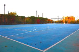 a tennis court with a blue tennis court at Appartement avec vue sur l'Atlas et piscine in Marrakesh