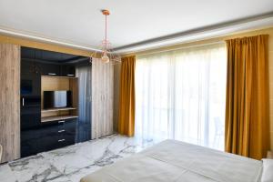 a bedroom with a bed and a tv and a window at Azure W B&B in San Lawrenz
