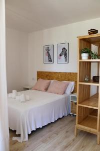 a bedroom with a large white bed and shelves at Casal Do Crego in O Grove