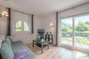 ein Wohnzimmer mit einem Sofa und einem großen Fenster in der Unterkunft Résidence Le Cristal - Nant Blanc 2 - Happy Rentals in Chamonix-Mont-Blanc